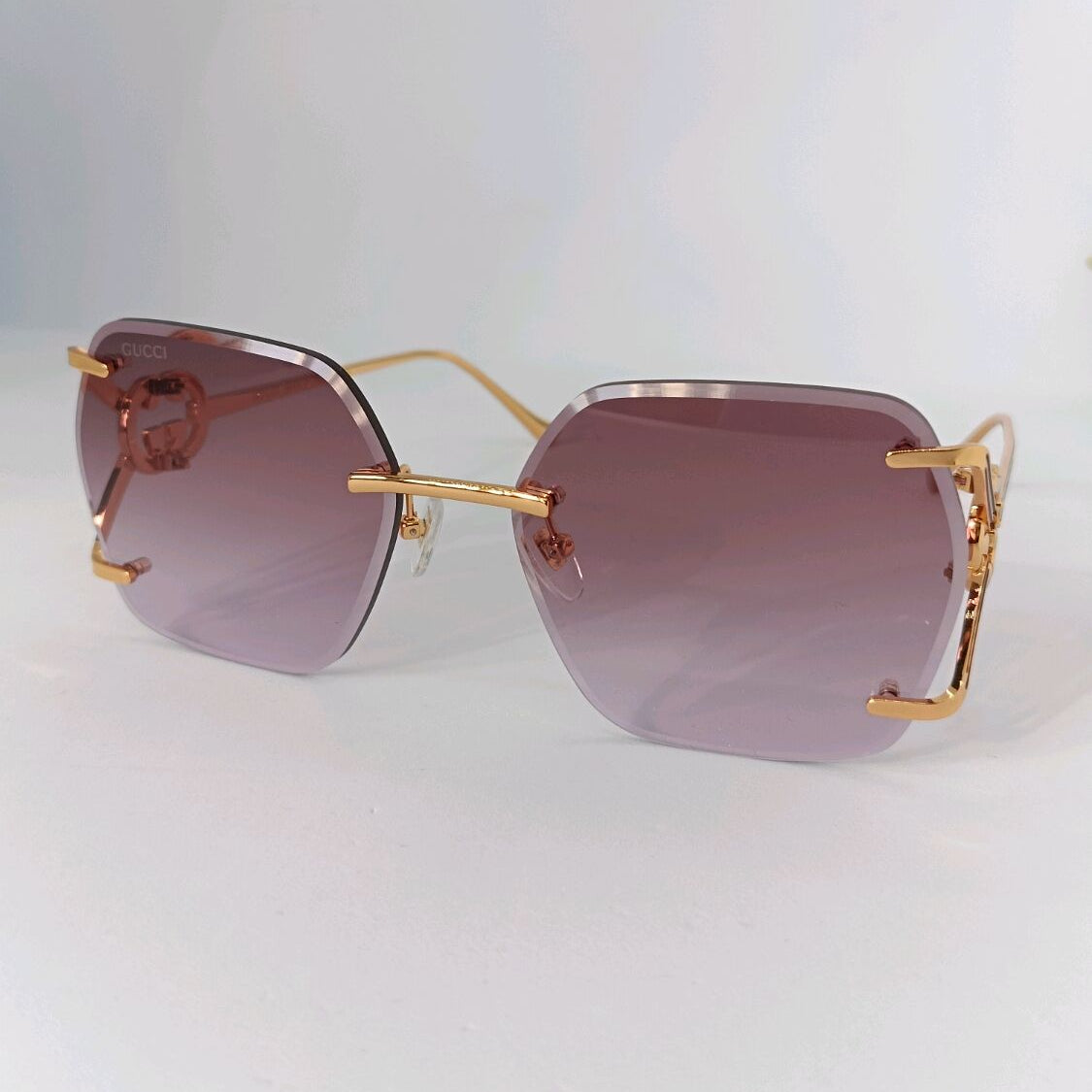 Gucci luxury rimless sunglasses with gradient purple lenses and gold-tone hardware.