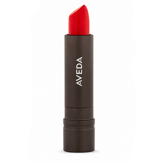 Red lipstick with Aveda branding on a white background