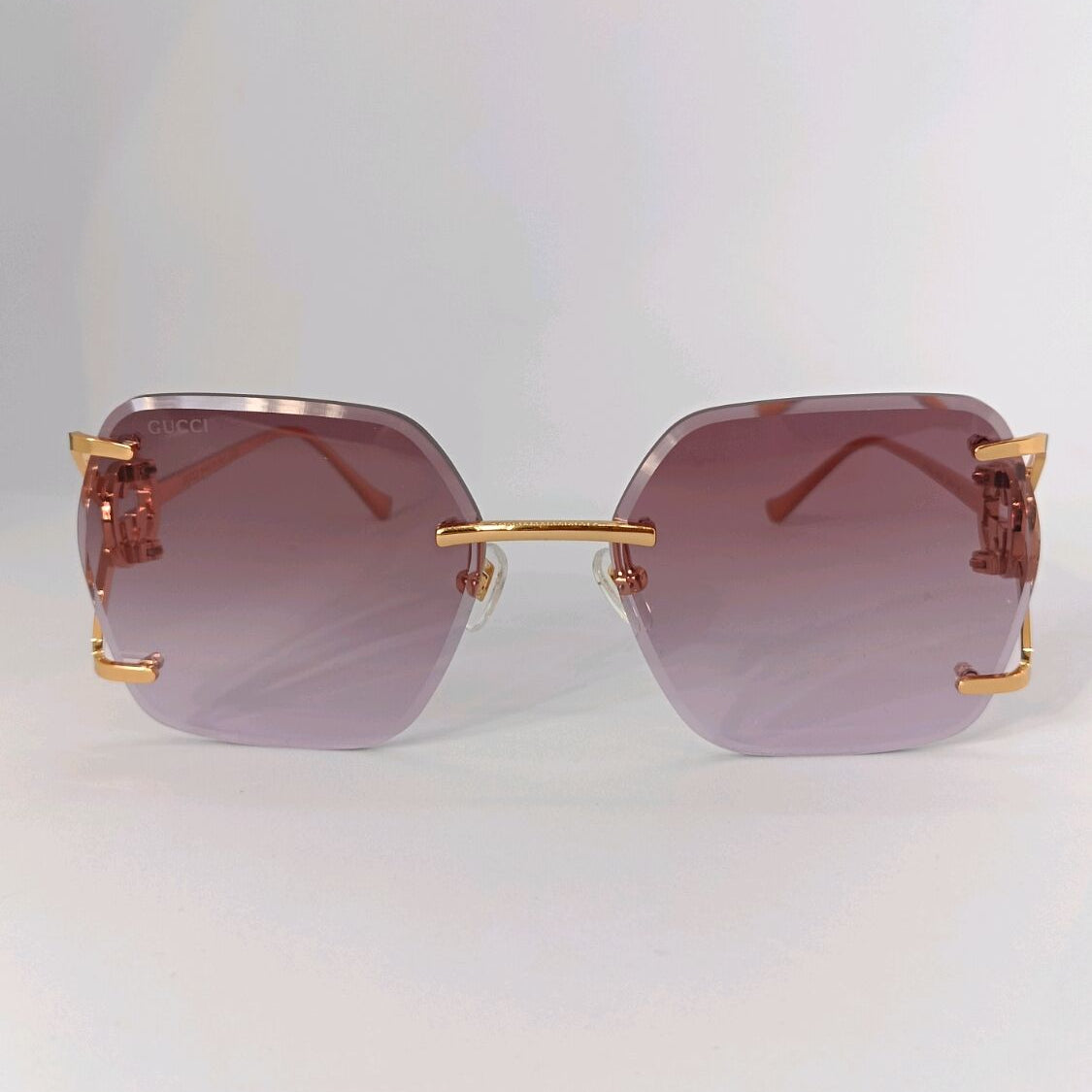 Gucci luxury sunglasses with purple gradient lenses and gold-tone metal frames.