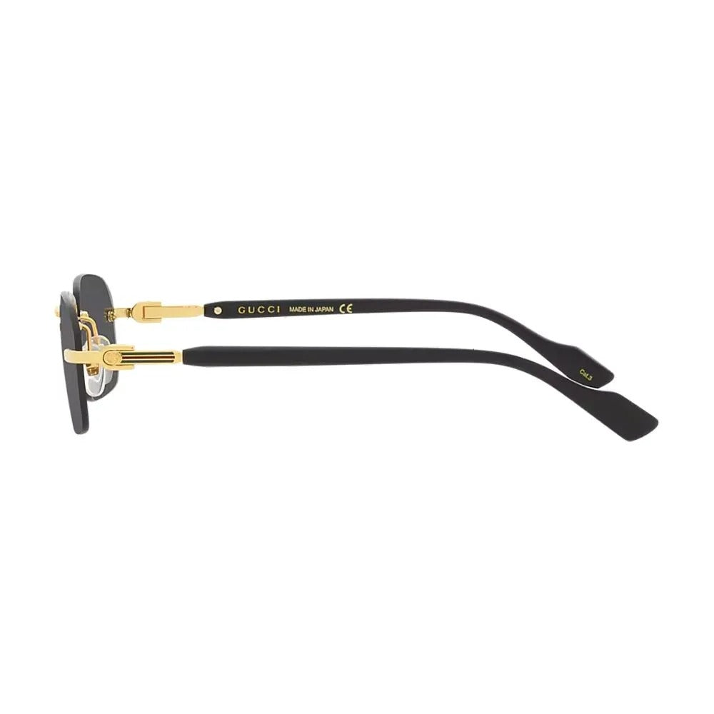 Side view of black Gucci luxury sunglasses with gold metal accents and temple branding.