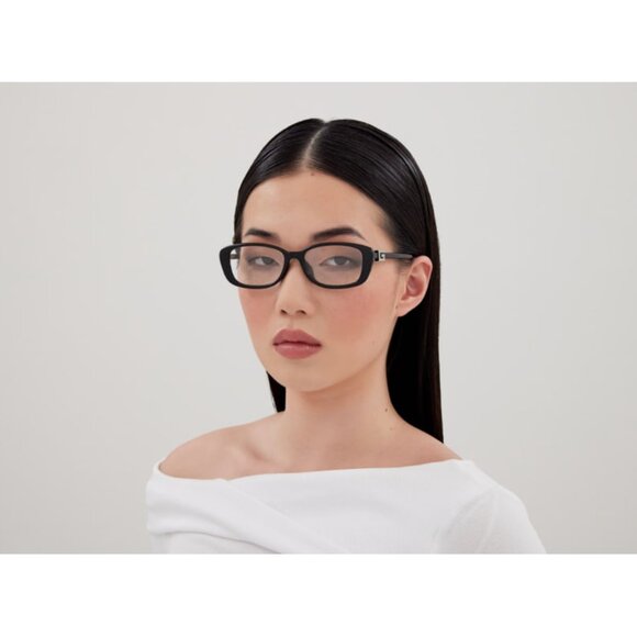 Woman wearing black rectangular prescription glasses with clear lenses.
